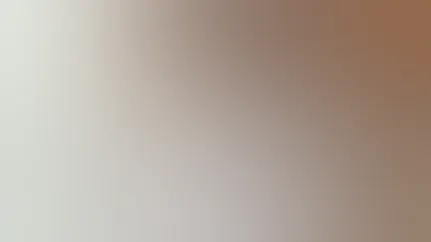 A woman gazes out the window while drinking a glass of kombucha.