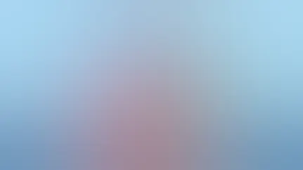 A woman sits in a bean bag chair writing notes in her notebook.