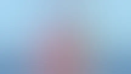 A woman sits in a bean bag chair writing notes in her notebook.