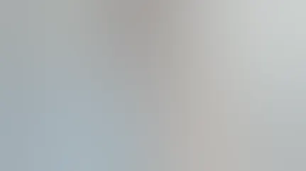 A woman carries a grocery bag full of fresh produce into her home.