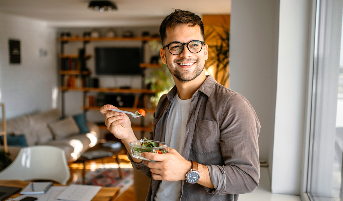 A man gets his fiber fix by eating a vegetable salad for an afternoon snack.