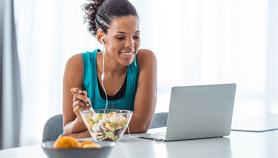 A woman eats a salad after coming home from a walk to support her fertility.
