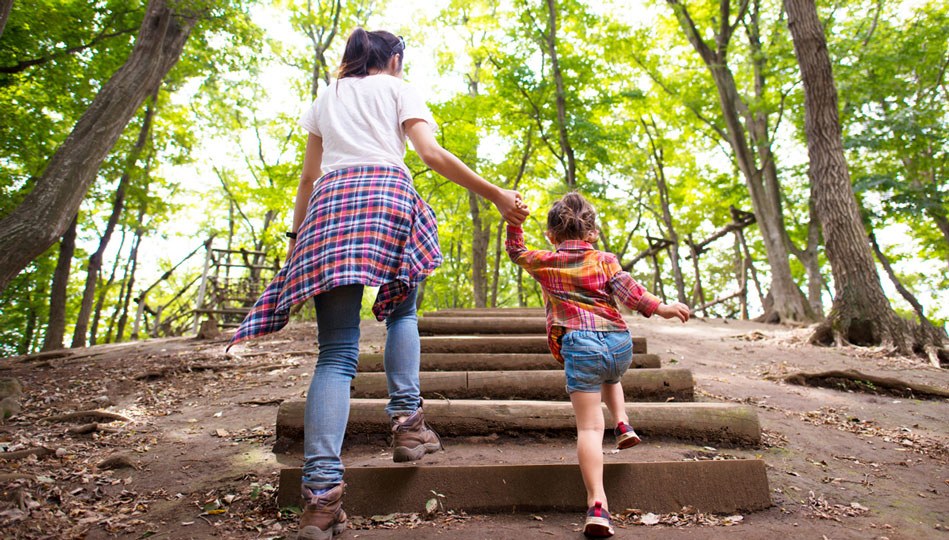 A mom and her daughter go for a nature walk after school.