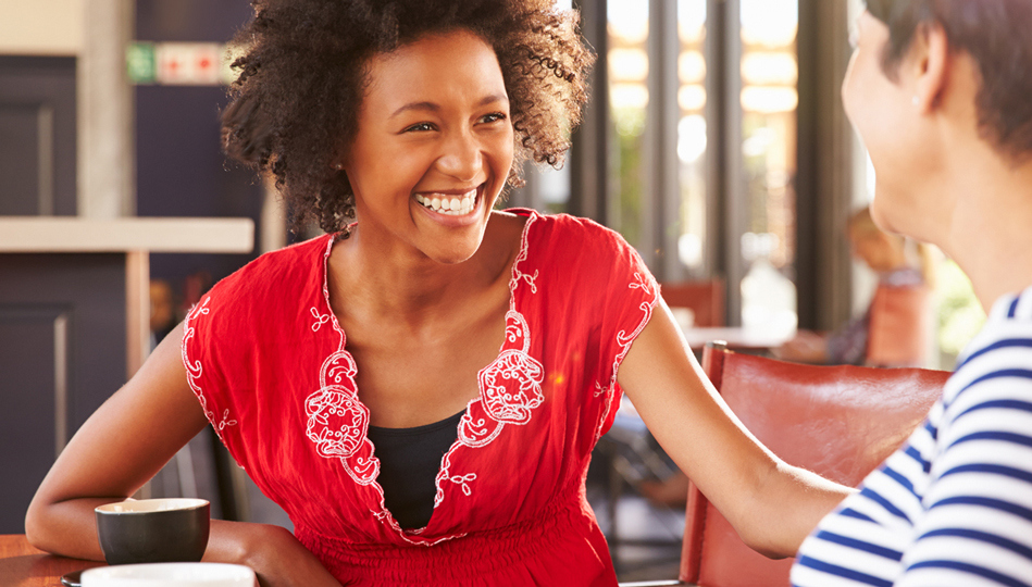Two women laugh during conversation.