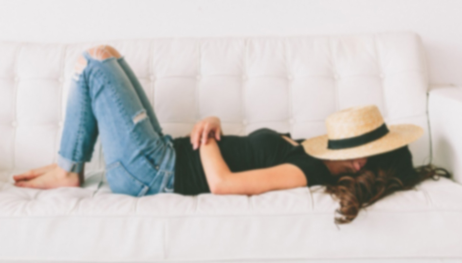 A woman lays back on her couch for an afternoon nap.