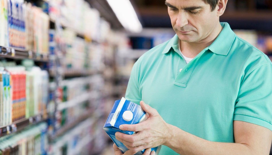 Person checking out a half gallon of something at the grocery store.