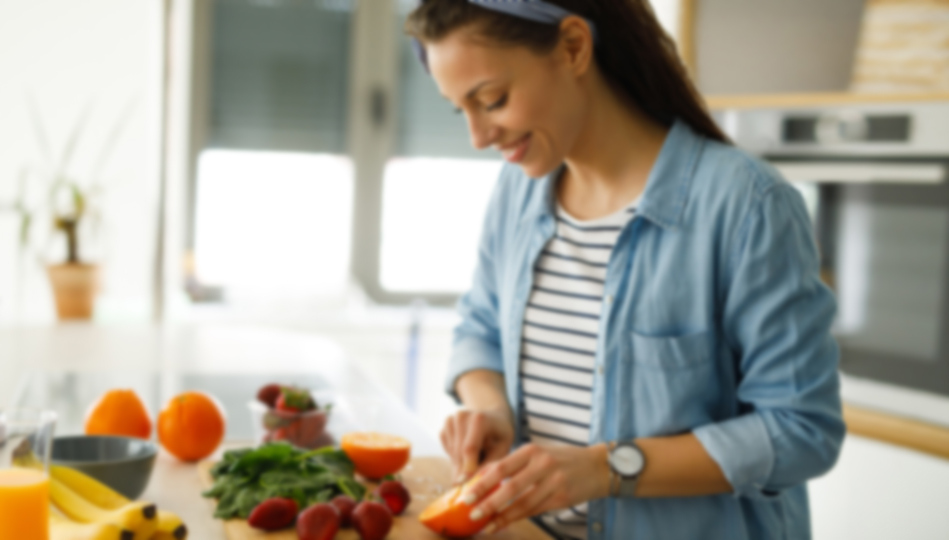 A woman prepares fresh fruits and vegetables for her weekly recipes.