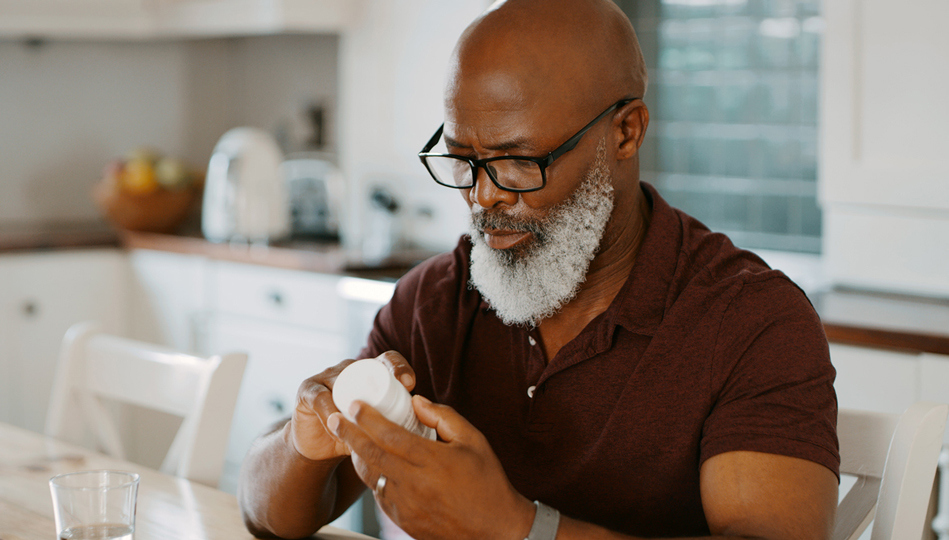 A man reads the label on his supplement bottle.