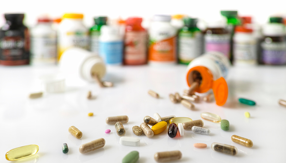 An overwhelming amount of medications are spilled over the countertop.