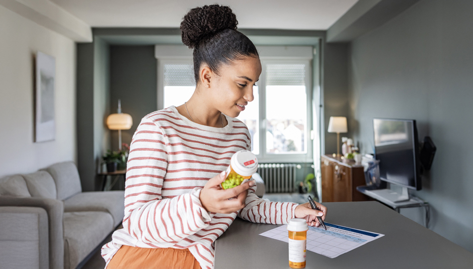 A woman inspects her medication bottle.