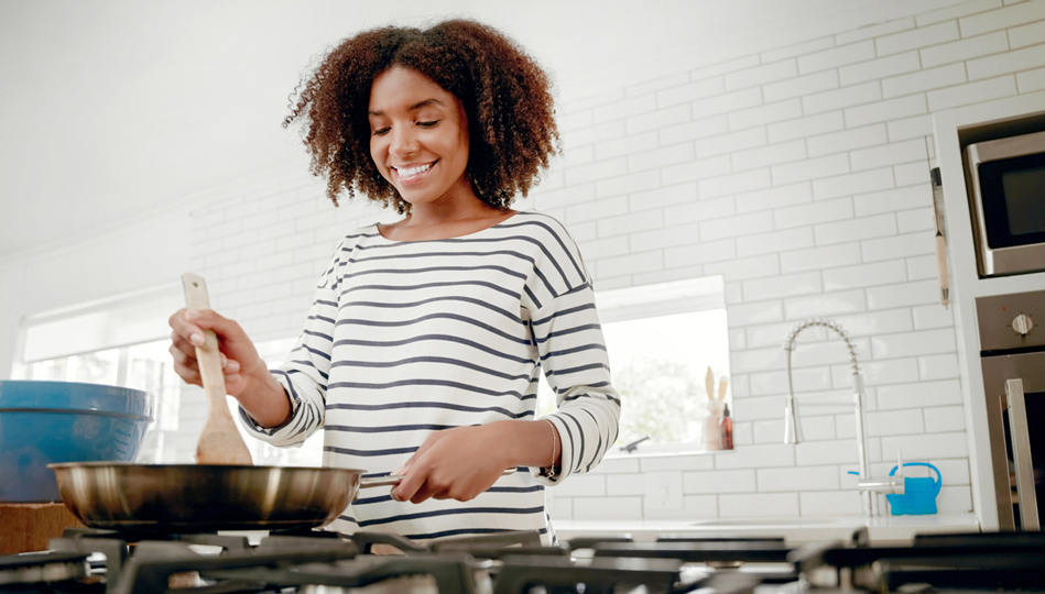 A woman cooks a fresh healthy dinner, low in cholesterol.