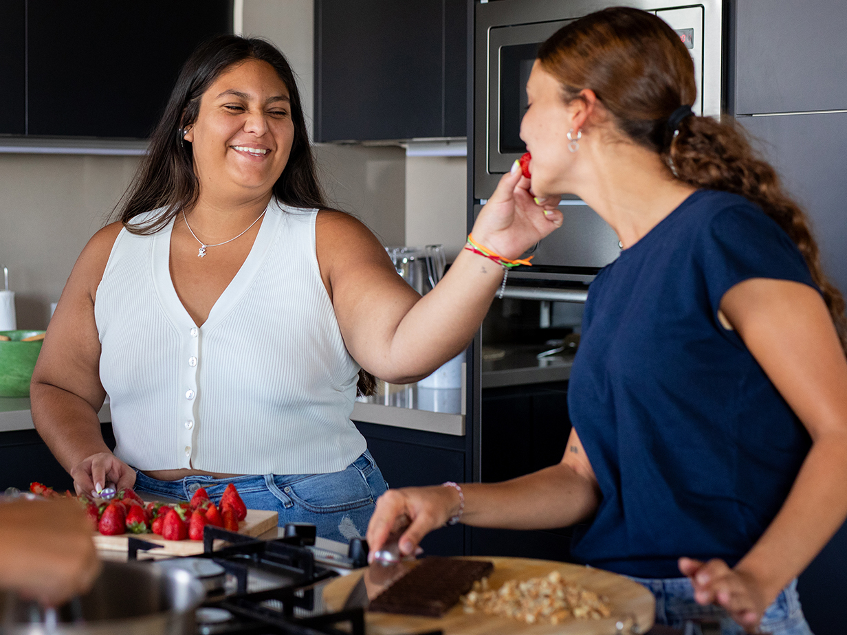 Two people sharing strawberries.